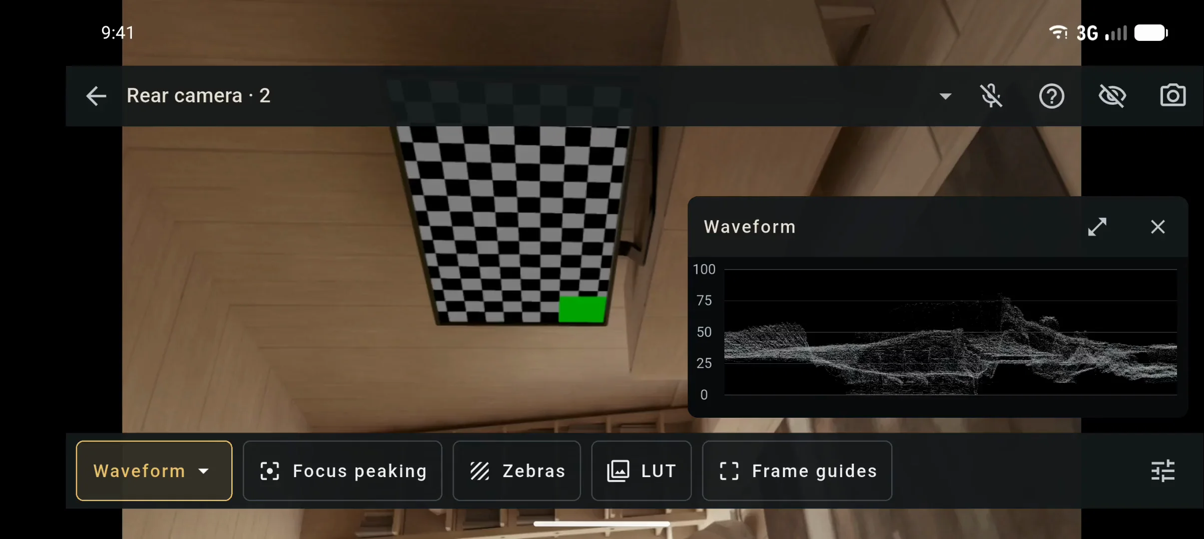 Monitor on Android in landscape, recorded: the waveform open over a live scene, zebras and focus peaking switched on, frame guides added, and the scope expanded.